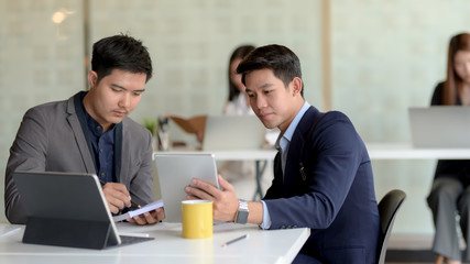 Close up view of two of businessman discussing on their task in modern co working space room