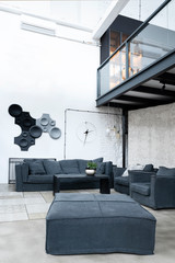 Interior of living room in loft apartment in industrial style. Modern grey furniture, design sofa and white brick wall. Minimal and simple scandinavian indoors. Vertical. 