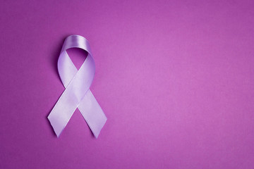 Wall Mural - Purple awareness ribbon on a purple backgroundwith copy space.