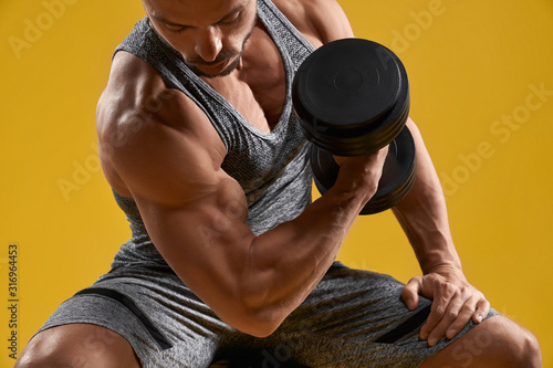Fotografía Muscular young gentleman pumping up biceps