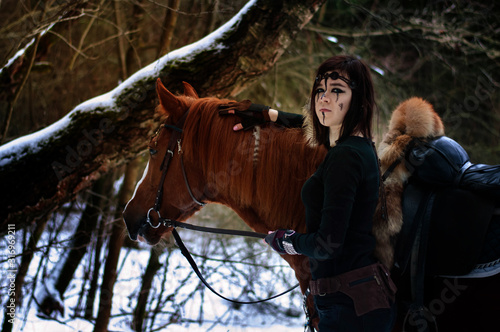 Cuadros en Lienzo a Viking girl next to a red horse painted in black runes.