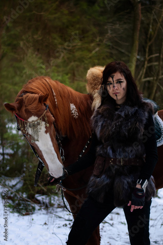 Cuadros en Lienzo a Viking girl next to a red horse painted in black runes.