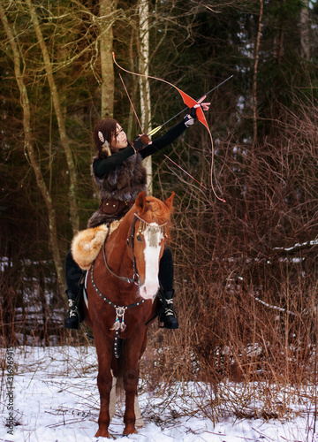 Fotografía a Viking girl riding a red horse painted in black runes