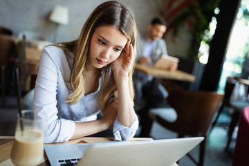 Wall Mural - Portrait of tired young business woman with laptop