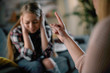 © JustLife - Mother scolding daughter. Scared girl covering ears .