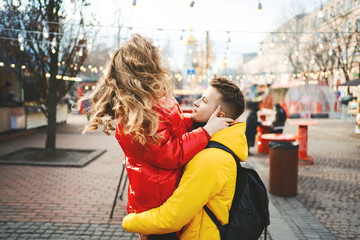 Young passionate couple having fun together and looking happy, handsome young man carrying his girlfriend while walking on the street. spending time together, having a date. urban background. Romantic