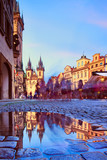 Fototapeta Paryż - St Mary Tyn Church in Prague with reflection in a pool of water after Summer rain with tourists walking by towards Old Market Square in Prague
