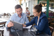 © auremar - man and woman meeting in cafe looking at tablet pc