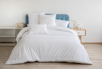 interior with white bed linen on the sofa. bedroom with bed, white bedding, and bedside table. white