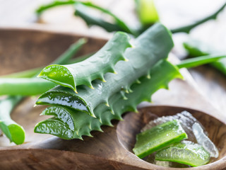 Wall Mural - Fresh aloe leaves close up on wooden background.