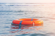Orange Lifebuoy In Sea On Water. Life Ring Floating On Top Of Water. Life Ring In Ocean.