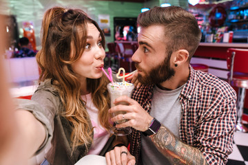 Sticker - Couple in retro bright street food cafe take a selfie by camera.