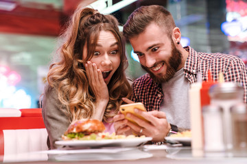 Canvas Print - Screaming young loving couple using mobile phone.