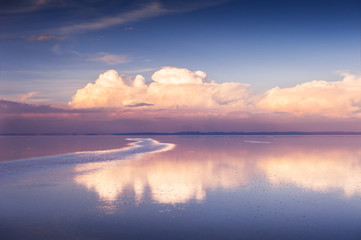 Mirror surface of Salar de Uyuni salt flat at sunset in Bolivia. South America landscapes