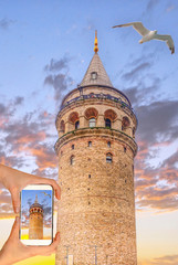 Wall Mural - Travel concept - tourist taking photo of Golden Horn against Galata tower, Istanbul, on mobile gadget, Turkey