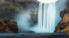 Alone Tourist Overlooking Waterfall At Skogafoss, Iceland