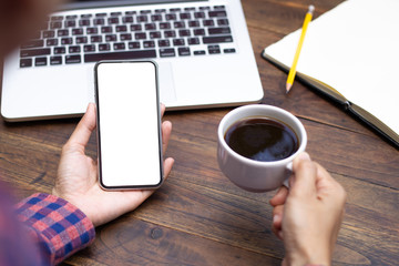 Mockup image blank white screen cell phone.woman hand holding texting using mobile on desk at coffee shop.background empty space for advertise text.people contact marketing business,technology 