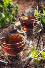 Wall Mural - A cup of melissa tea with herbs on wooden table