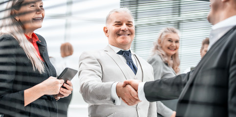 close up. smiling business people greet each other with a handshake.