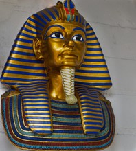 Golden And Blue Egyptian Statue Hung From A White Wall