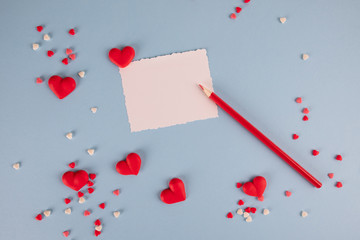 Wall Mural - Love notes. Design with white blank card red heart and red pencil. hearts on blue background. Top view Flat lay .