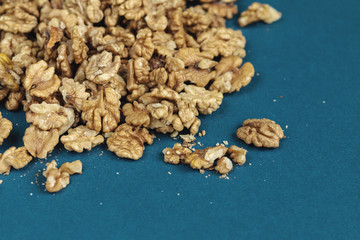 Walnut seeds texture top view on blue color background, space for text, organic healthy food concept