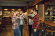 © Studio Romantic - Group of happy friends clinking glasses with beer at a sports bar.