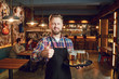 © Studio Romantic - Bearded waiter with a tray of glasses of beer against the background of a pub bar