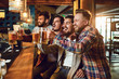 © Studio Romantic - A group of guys watching sports on tv in a pub bar.