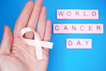 World Cancer Day, February 4th. Woman Holds Pink Ribbon On Hand. Healthcare And Medicine Concept.