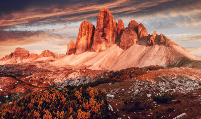 Awesome alpine highlands during sunset. Amasing nature landscape. Tre Cime di Laveredo, three spectacular mountain peaks with colorful sky, Dolomites Alps, South Tyrol, Italy. Picture of wild area.