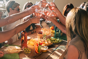 Group of happy and cheerful caucasian people women have fun all together drinking and toasting with red wine - friendship and holiday celebration concept with adult females