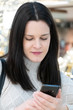 © cineberg - Brunette woman typing on her smartphone