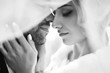 Black and white foto of amazing smiling wedding couple. Pretty bride and stylish groom posing  and kisses tenderly in the shadow of a flying veil. Romantic moment.Together. Wedding. Marriage.