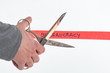 Male hand cutting through bureaucracy red tape with scissors isolated on white with a shallow depth of field and copy space