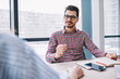 © BullRun - Smart businessman in casual wear communicating with colleagues at office