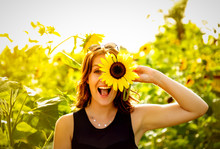Young Woman Laughs With A Sunflower On Her Face