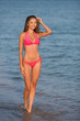 © popovich22 - Beautiful girl in a pink swimsuit on the ocean. Bright smile. Beautiful tan.