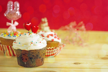 Canvas Print - Valentines day cupcake. A cupcake with white cream is decorated with two red hearts on a red copy space background. Beautiful St. Valentine's Day card