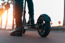 Close Up Image Of A Young Woman On An Electric Scooter During Sunset