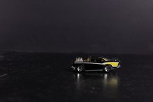 Selective Focus Shot Of A Black And Yellow Toy Sports Car On A Black Surface