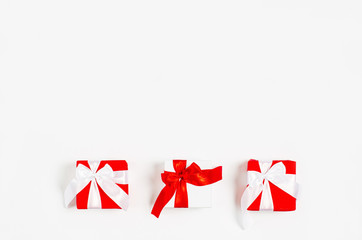 The concept of Valentine's Day, March 8, holiday, celebration, anniversary. Gift boxes with red ribbons on a white background.