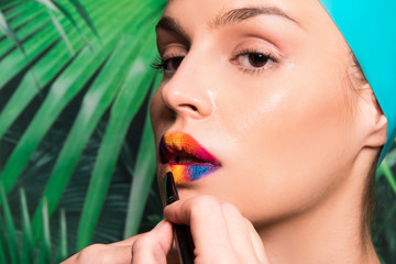 applying colorful make up on lips, hand brush of make up artist,  glow skin, perfect face fashion model