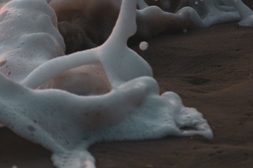 Wall Mural - Closeup shot of sea waves on a sandy surface - great for a wallpaper