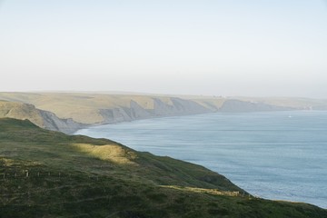 Wall Mural - High angle shot of hills covered in the greenery surrounding the ocean