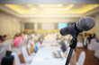 © nattanan - Microphone over the blurred business forum Meeting or Conference Room Concept, Blurred background.