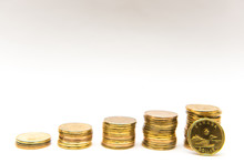 Canadian  Dollar Coins Loonies Stacked Into Five Ascending Piles On White Background.