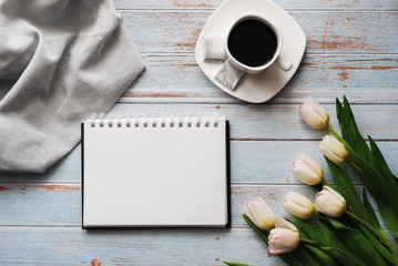 Wall Mural - Bouquet of white tulips with an empty notebook, a Cup of coffee on a wooden background