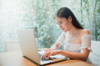 © 2April - A woman sitting using a laptop on desk