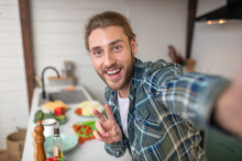 Smiling man making selfie on his kitchen